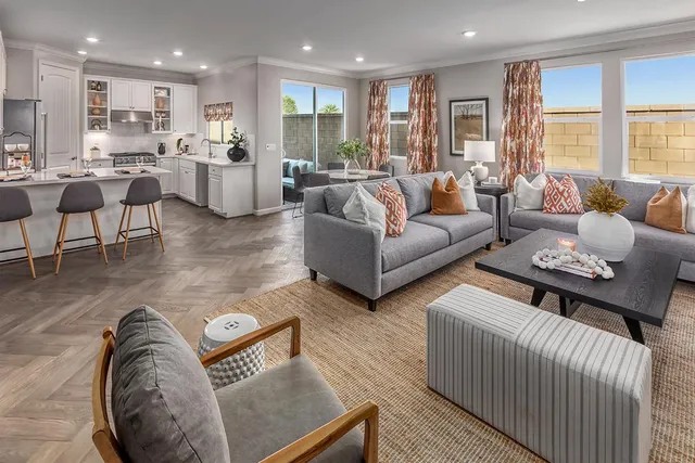a living room with furniture kitchen view and a large window