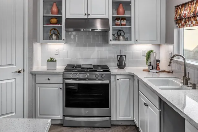 a kitchen with stainless steel appliances granite countertop a stove and cabinets