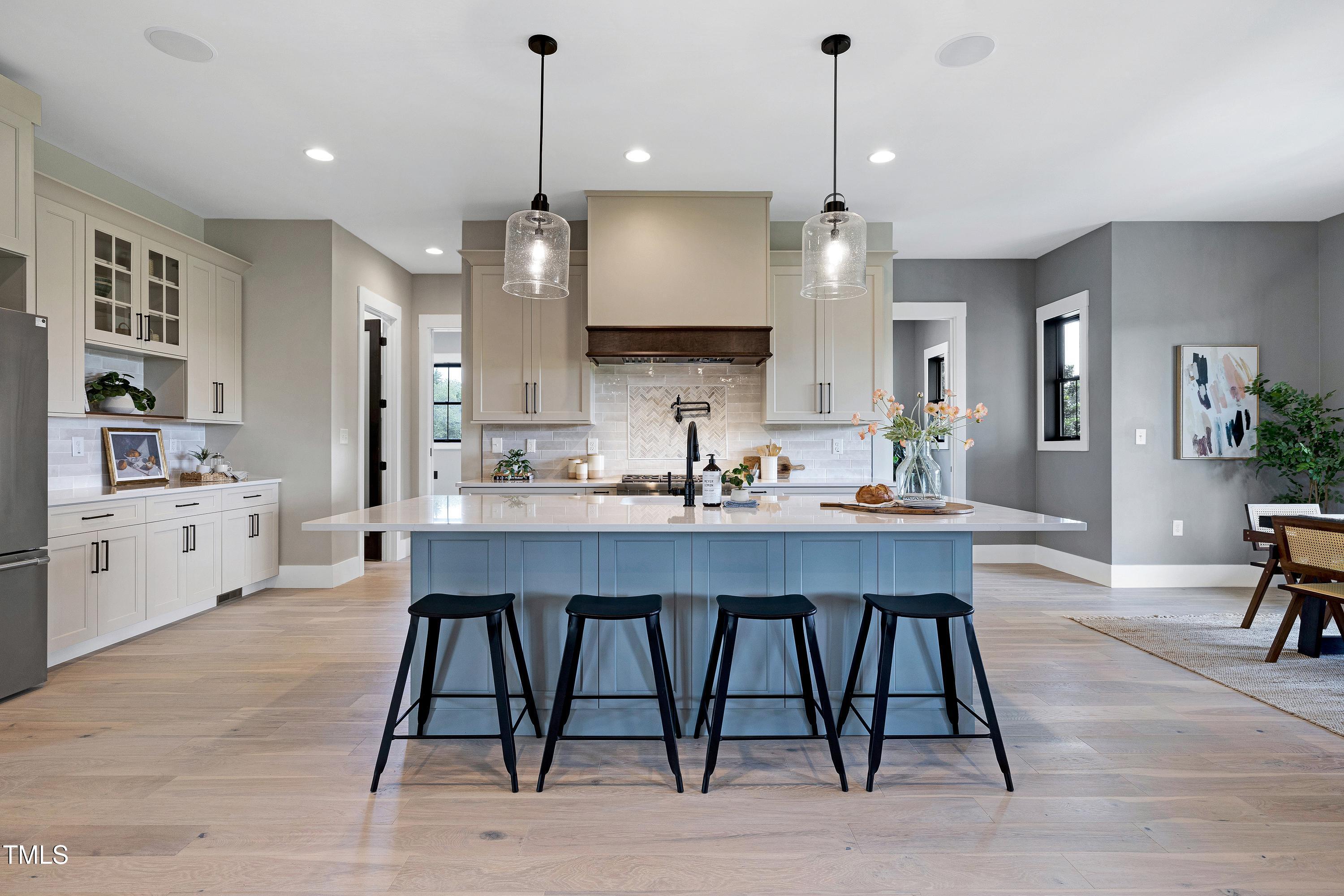 6509 Zebulon Road Wake Forest, NC 27587 - Photo 11 of 100 a kitchen with kitchen island a dining table chairs sink and cabinets