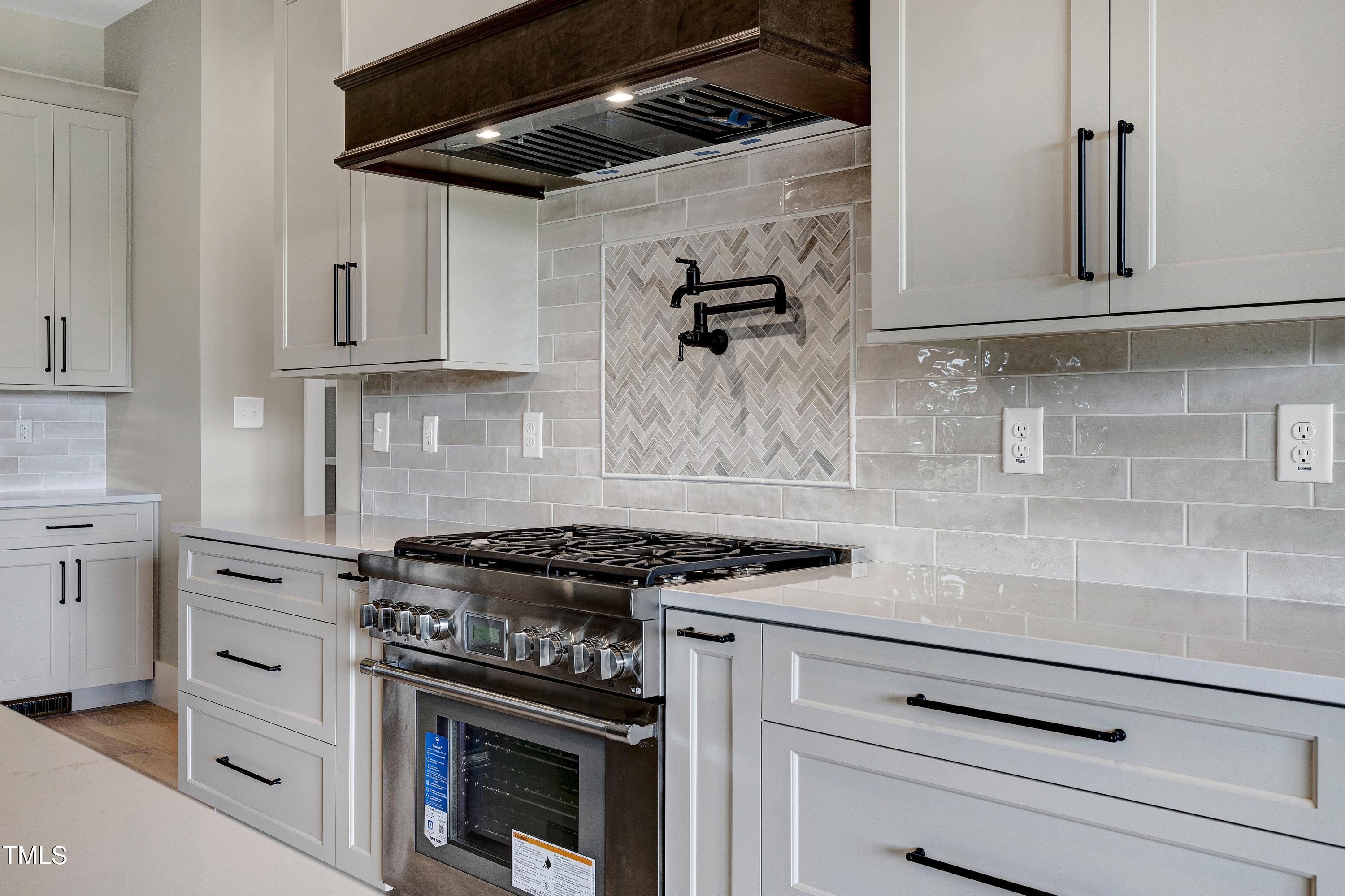 6509 Zebulon Road Wake Forest, NC 27587 - Photo 52 of 100 a kitchen with stainless steel appliances granite countertop white cabinets and a stove