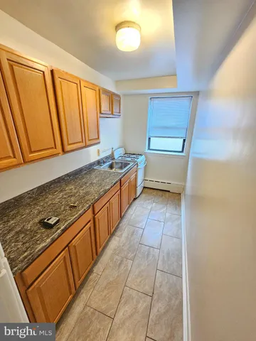 a kitchen with wooden cabinets and a stove top oven