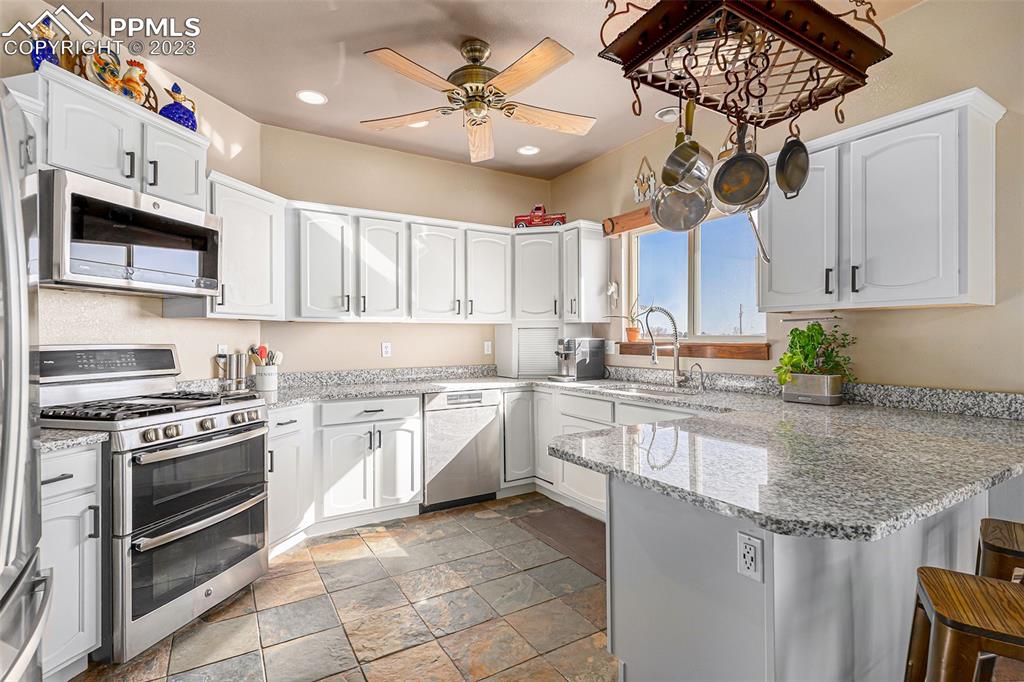 14965 Tanner Trail Elbert, CO 80106 - Photo 17 of 50 a kitchen with stainless steel appliances granite countertop a stove and cabinets