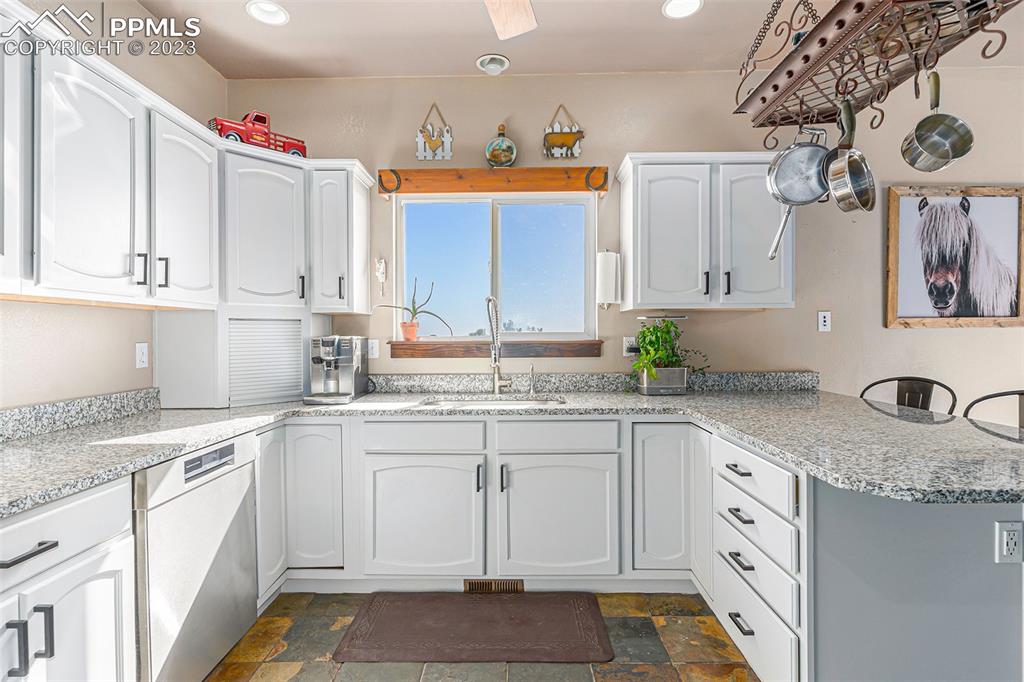 14965 Tanner Trail Elbert, CO 80106 - Photo 18 of 50 a kitchen with granite countertop a sink and cabinets