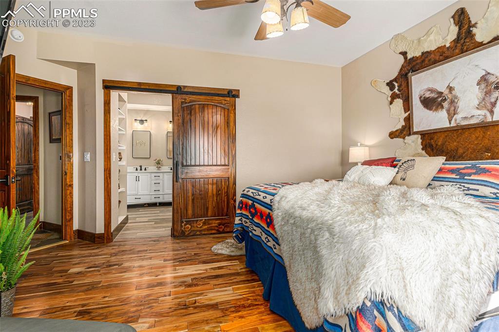 14965 Tanner Trail Elbert, CO 80106 - Photo 22 of 50 a bedroom with a bed and a chandelier