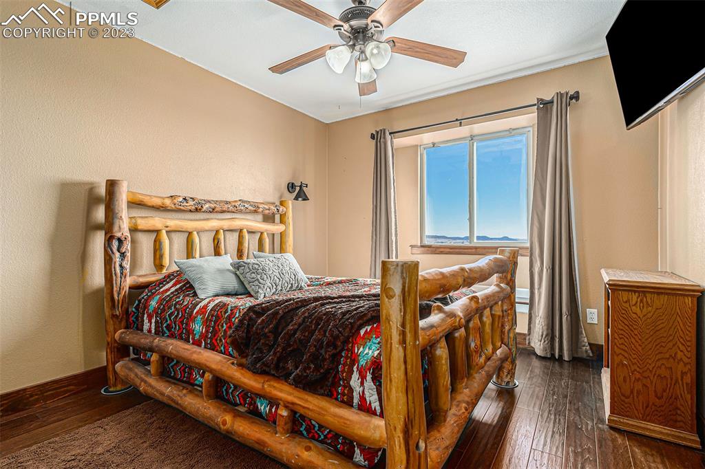 14965 Tanner Trail Elbert, CO 80106 - Photo 28 of 50 a bedroom with a bed and wooden floor