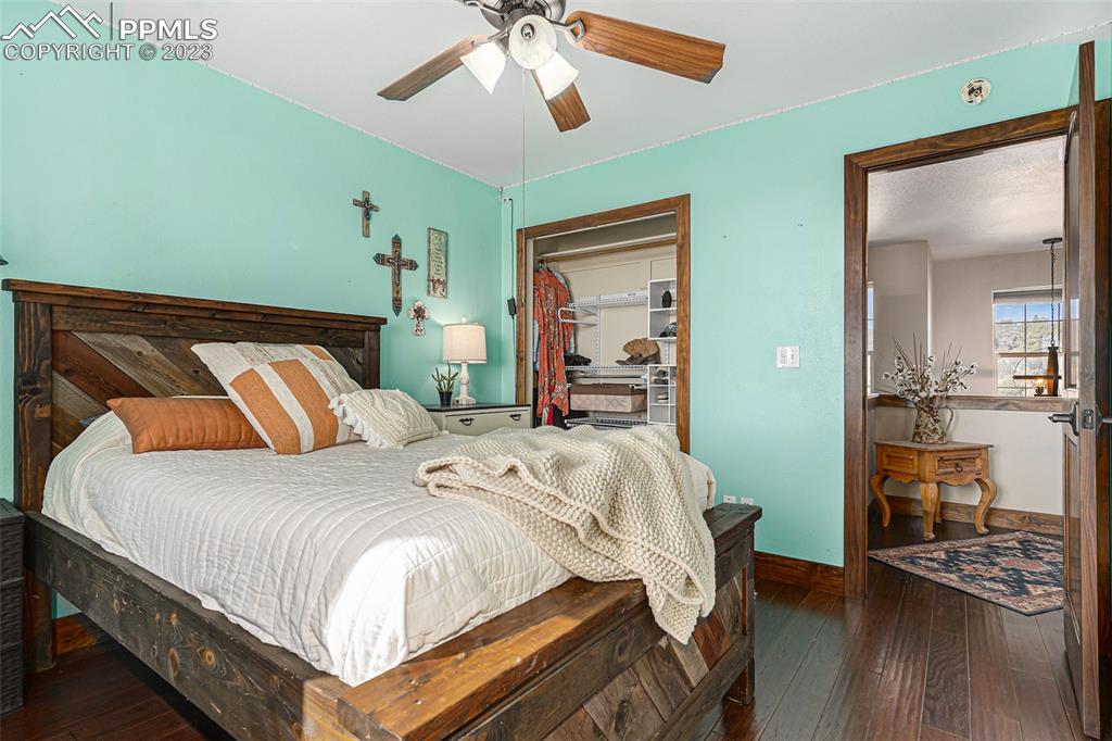 14965 Tanner Trail Elbert, CO 80106 - Photo 31 of 50 a bedroom with a bed and a chandelier