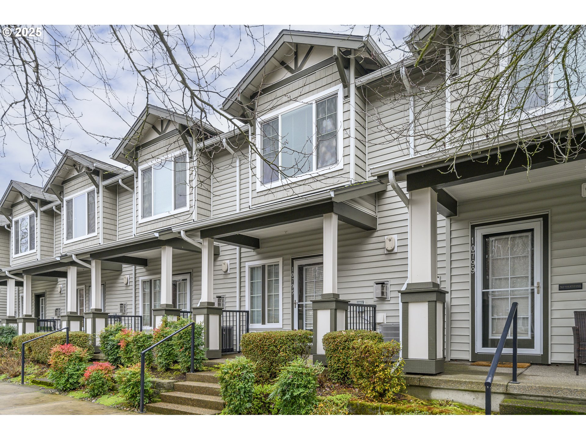 10795 Northeast Gateway Place Hillsboro, OR 97006 - Photo 26 of 27 a view of a white house with large windows and a small yard