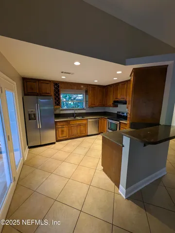 a kitchen with stainless steel appliances granite countertop a refrigerator and a stove top oven