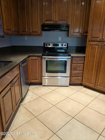a kitchen with granite countertop a stove top oven microwave and cabinets
