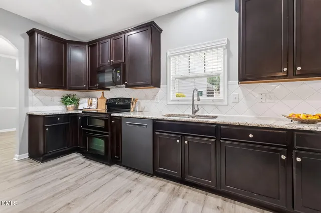 a kitchen with granite countertop wooden cabinets and a sink