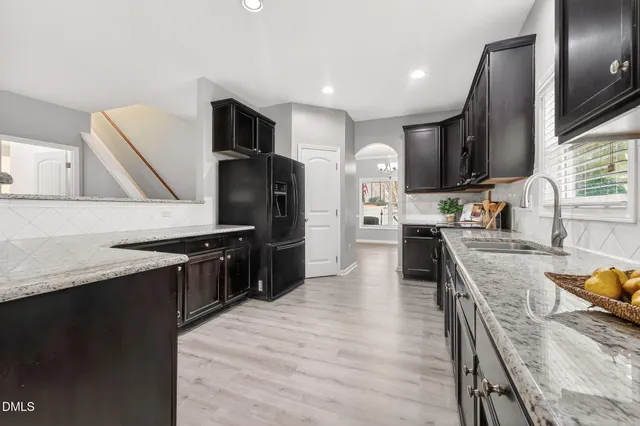 a large kitchen with stainless steel appliances granite countertop a stove refrigerator and a sink