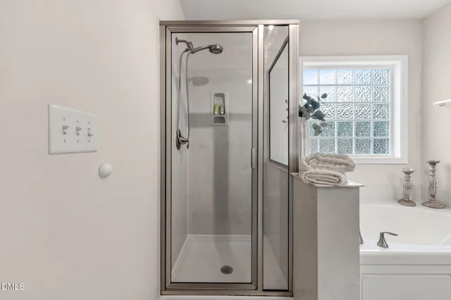 a bathroom with a shower a mirror and a sink