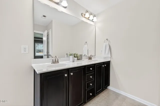 a bathroom with a double vanity sink and a mirror