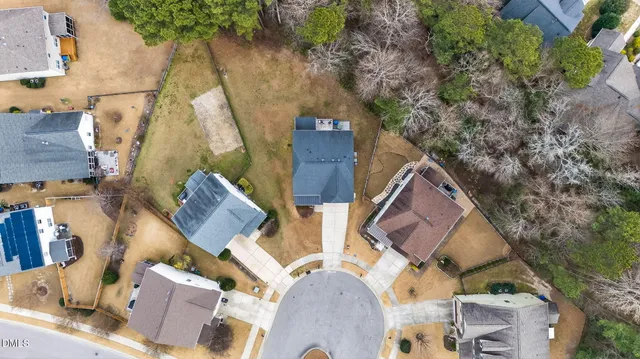 an aerial view of a house with a yard and wooden fence