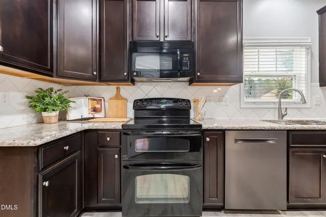 a kitchen with granite countertop a sink stainless steel appliances and cabinets