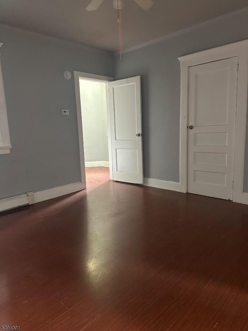 553 Bloomfield Avenue, Unit 2B Montclair, NJ 07042 - Photo 6 of 15 an empty room with wooden floor and windows with curtains