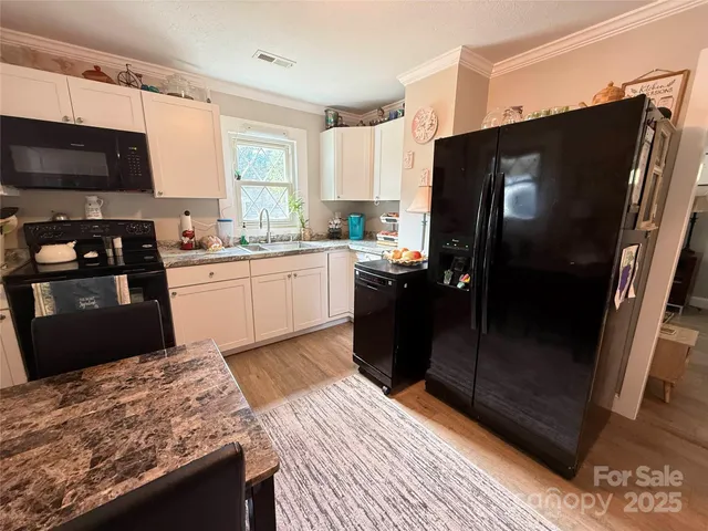 a kitchen with granite countertop a refrigerator stove and microwave