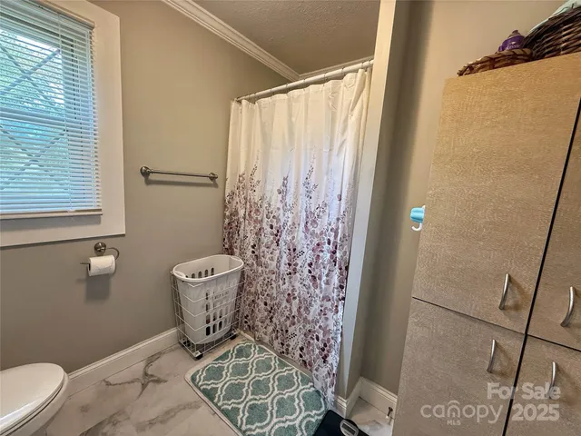 a bathroom with a toilet and a shower