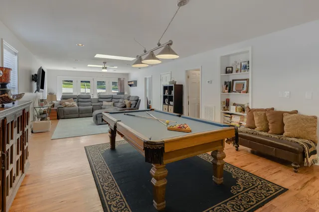 a living room with furniture a flat screen tv and a table