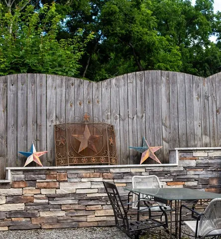 a view of table and chairs with wooden fence