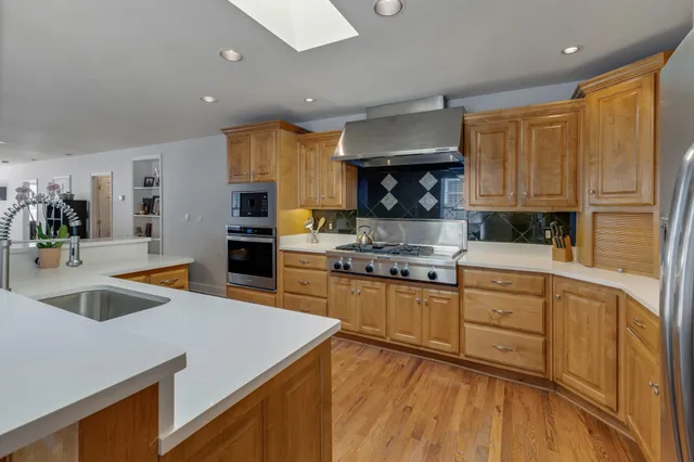 a kitchen with granite countertop a sink stainless steel appliances and cabinets