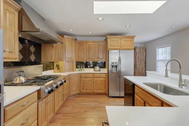 a kitchen with stainless steel appliances granite countertop a sink stove and refrigerator