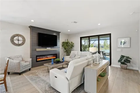 a living room with furniture a flat screen tv and a large window