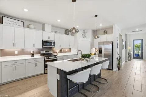 a kitchen that has a lot of cabinets a sink and appliances in it