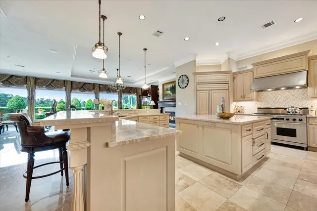 a kitchen with stainless steel appliances kitchen island granite countertop a stove a sink and a refrigerator
