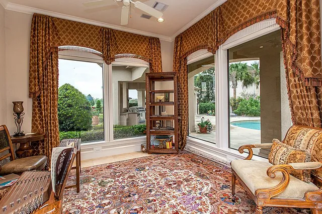 a living room with furniture fireplace and large windows