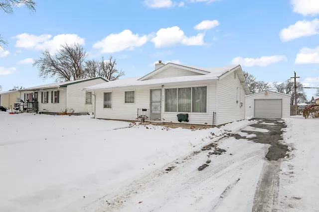a view of a white house with a yard covered in snow