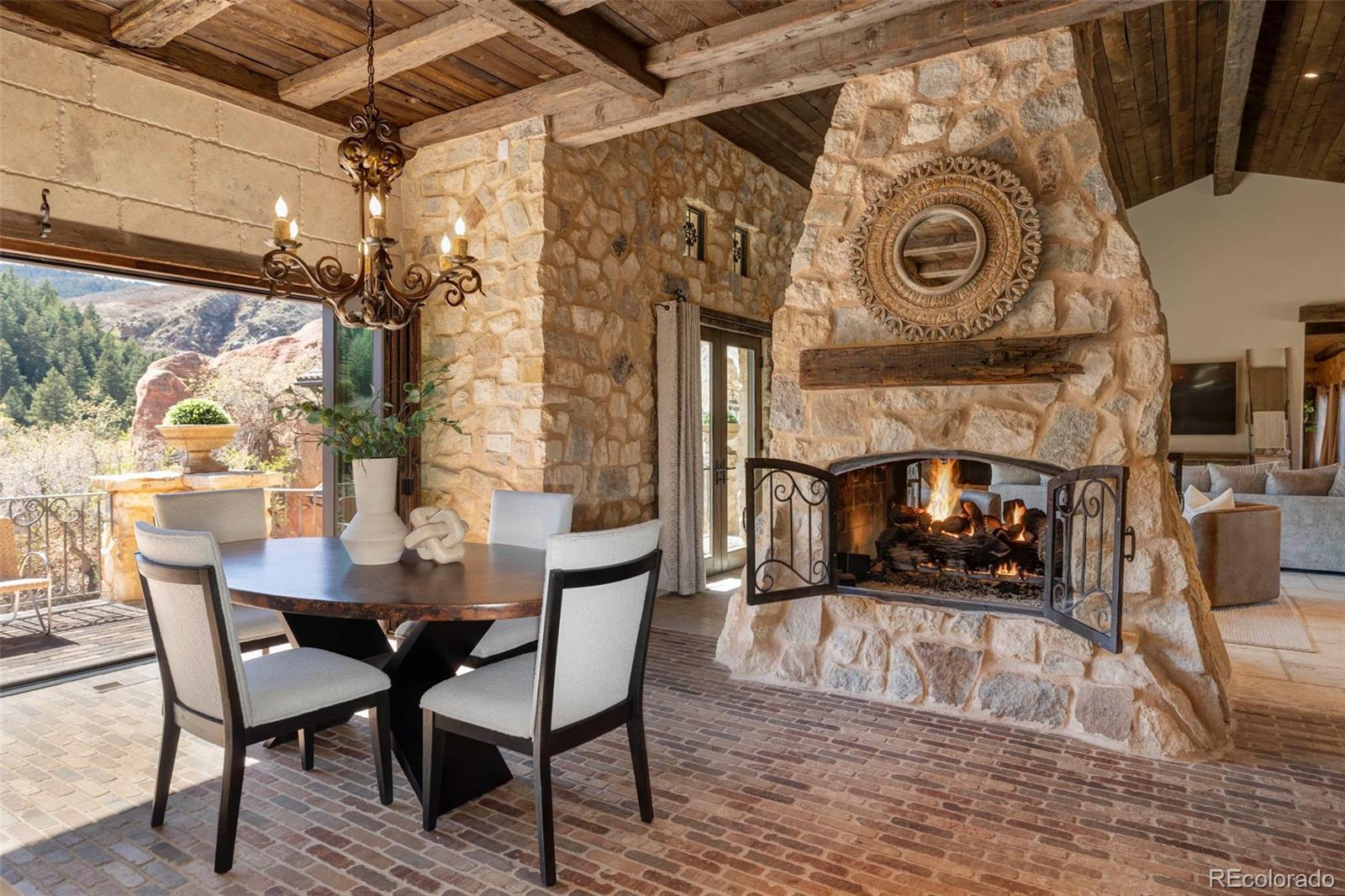 3755 North Rampart Range Road Littleton, CO 80125 - Photo 17 of 50 a view of a dining room with furniture and a fireplace