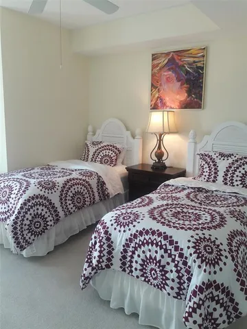 a bedroom with two beds and a painting on the wall