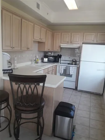 a kitchen with a stove a sink and white cabinets