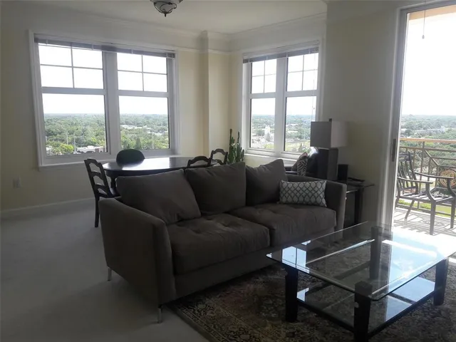 a living room with furniture and a floor to ceiling window