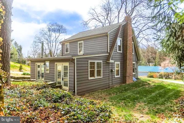 a view of a house with backyard and a tree