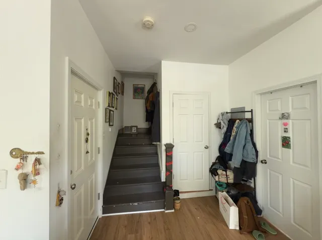 a view of a hallway with wooden floor and entryway