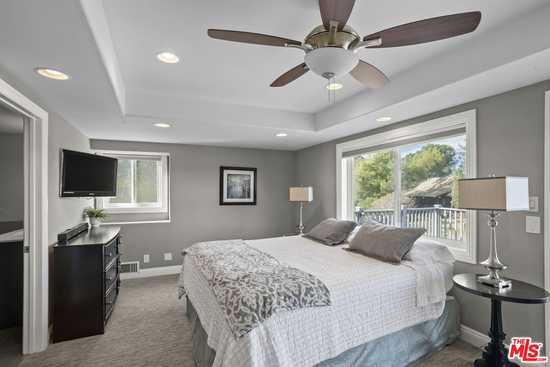 36880 East Benton Road Temecula, CA 92592 - Photo 20 of 75 a bedroom with a balcony a bed and a flat screen tv