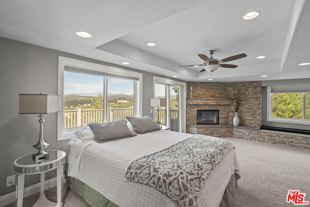 36880 East Benton Road Temecula, CA 92592 - Photo 21 of 75 a spacious bedroom with a large bed and a chandelier