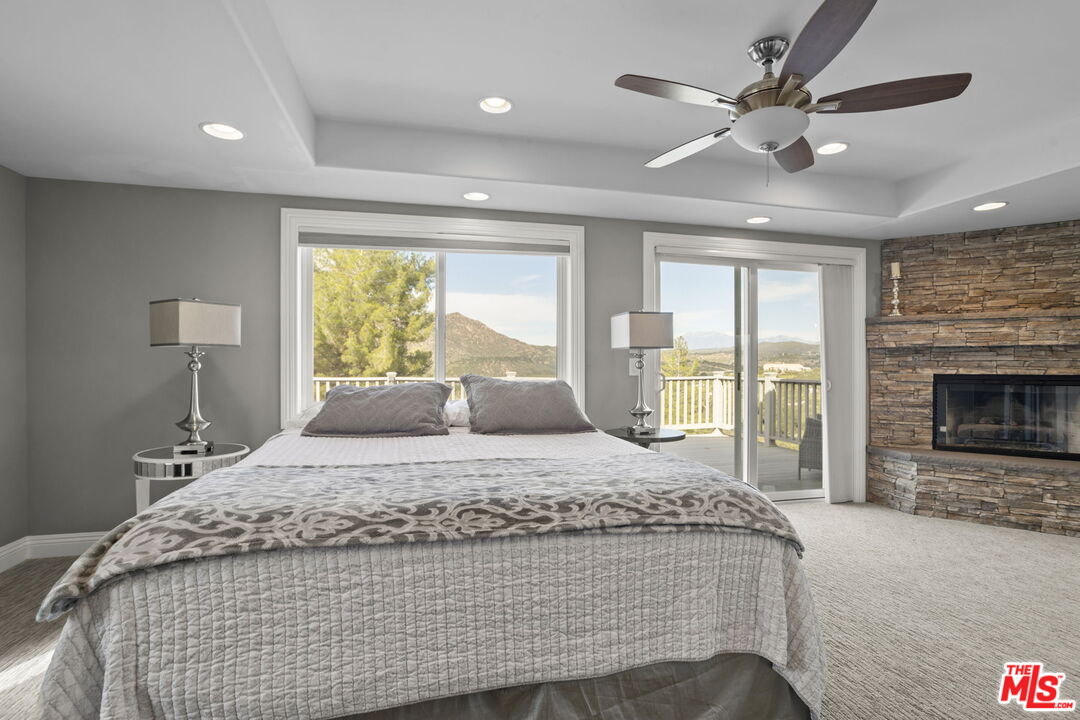 36880 East Benton Road Temecula, CA 92592 - Photo 22 of 75 a bedroom with a large bed chandelier and a large window