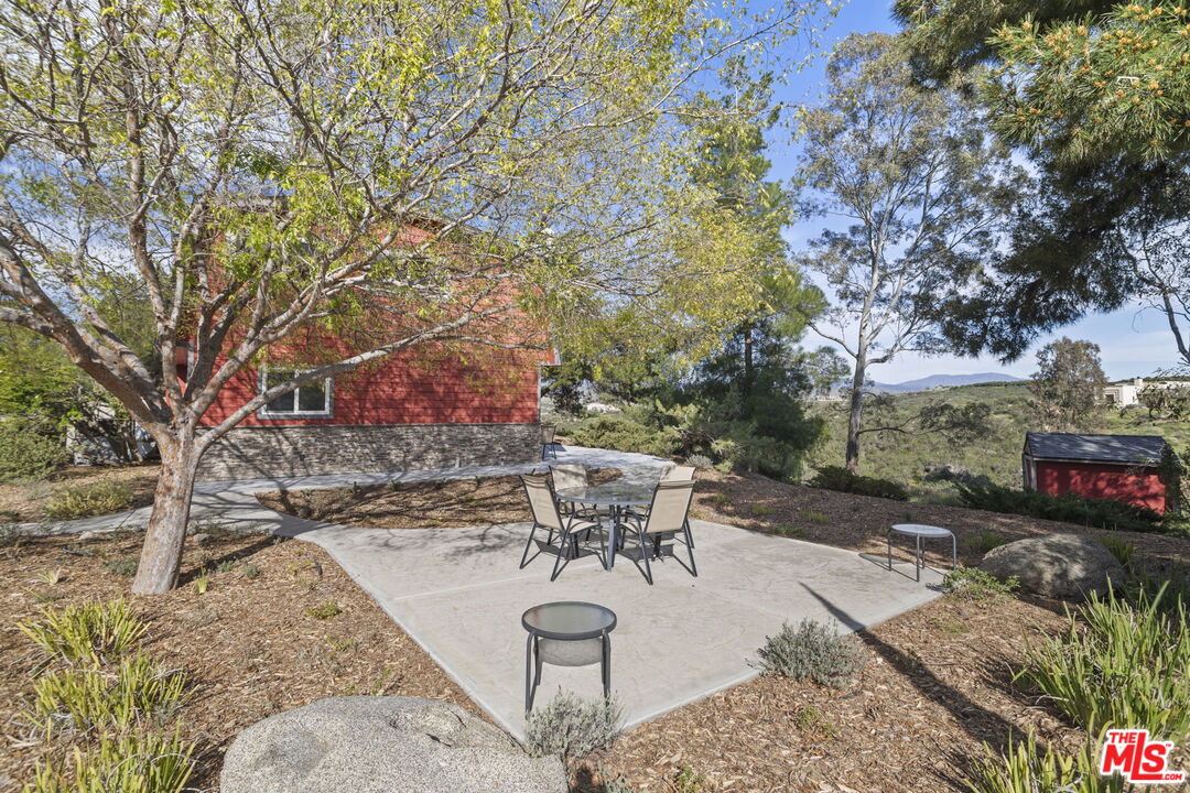 36880 East Benton Road Temecula, CA 92592 - Photo 34 of 75 a view of a backyard with table and chairs potted plants and a large tree