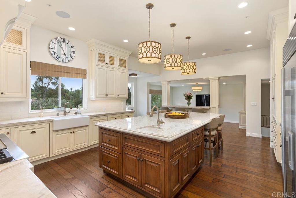 5315 La Crescenta Road Rancho Santa Fe, CA 92067 - Photo 4 of 17 a kitchen with a stove a refrigerator a sink dishwasher with a dining table and chairs