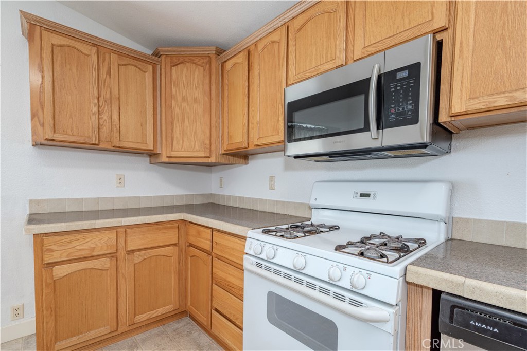 209 Rd Runner Lane Fountain Valley, CA 92708 - Photo 11 of 38 a kitchen with stainless steel appliances granite countertop a stove microwave and cabinets
