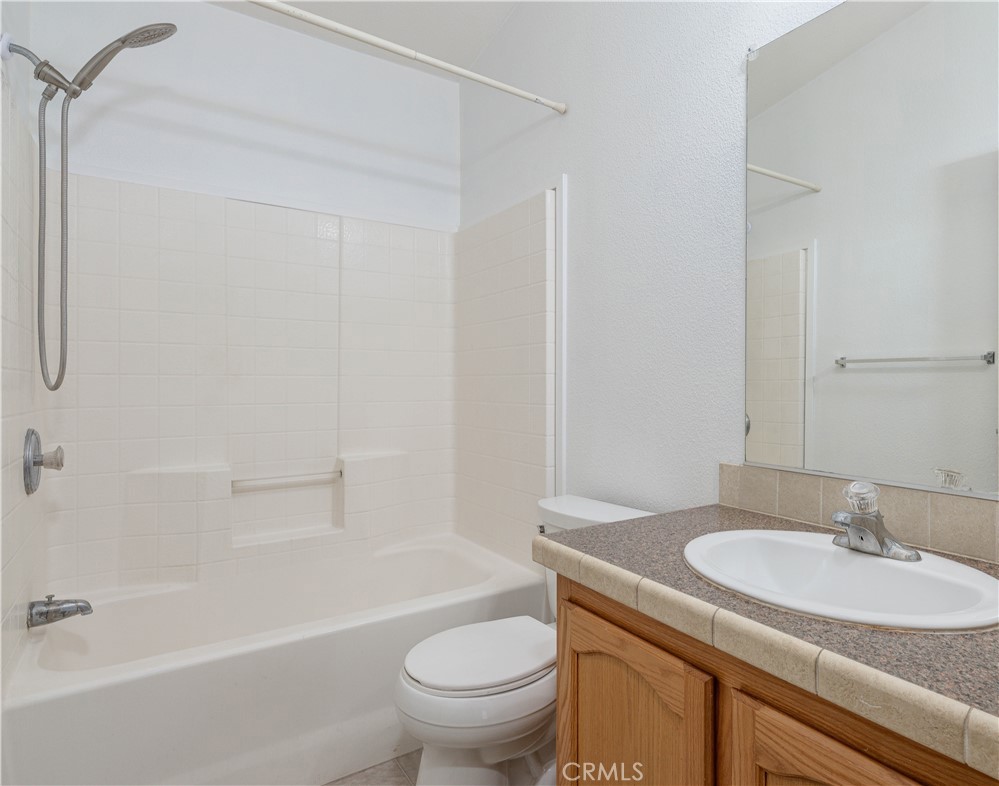 209 Rd Runner Lane Fountain Valley, CA 92708 - Photo 24 of 38 a bathroom with a granite countertop sink a toilet and a bathtub