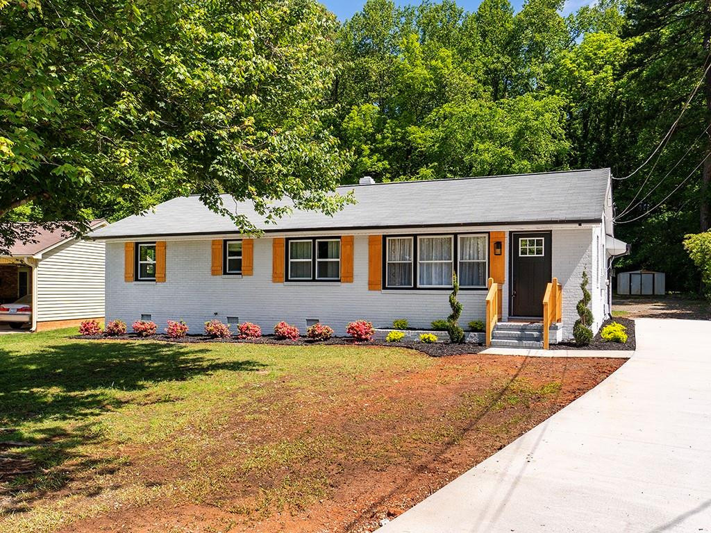 1720 Elder Way Burlington, NC 27215 - Photo 1 of 34 a front view of a house with a garden and trees