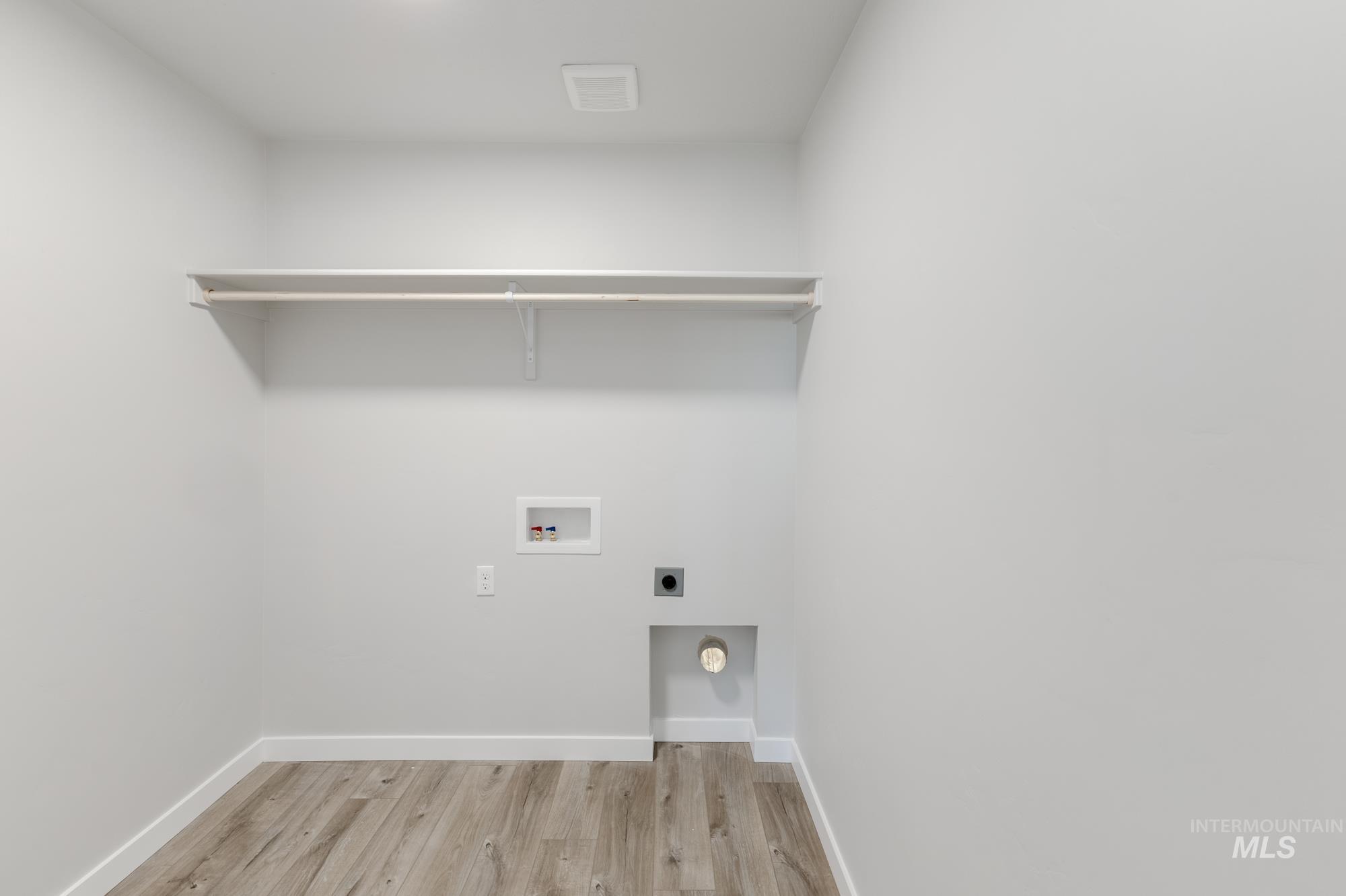 12853 Decatur Street Nampa, ID 83651 - Photo 20 of 24 Dedicated utility space featuring light-toned wood-finish flooring, white baseboards, and neutral wall paint