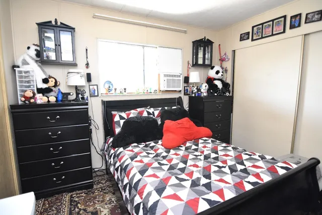 a bedroom with a bed and dresser with mirror