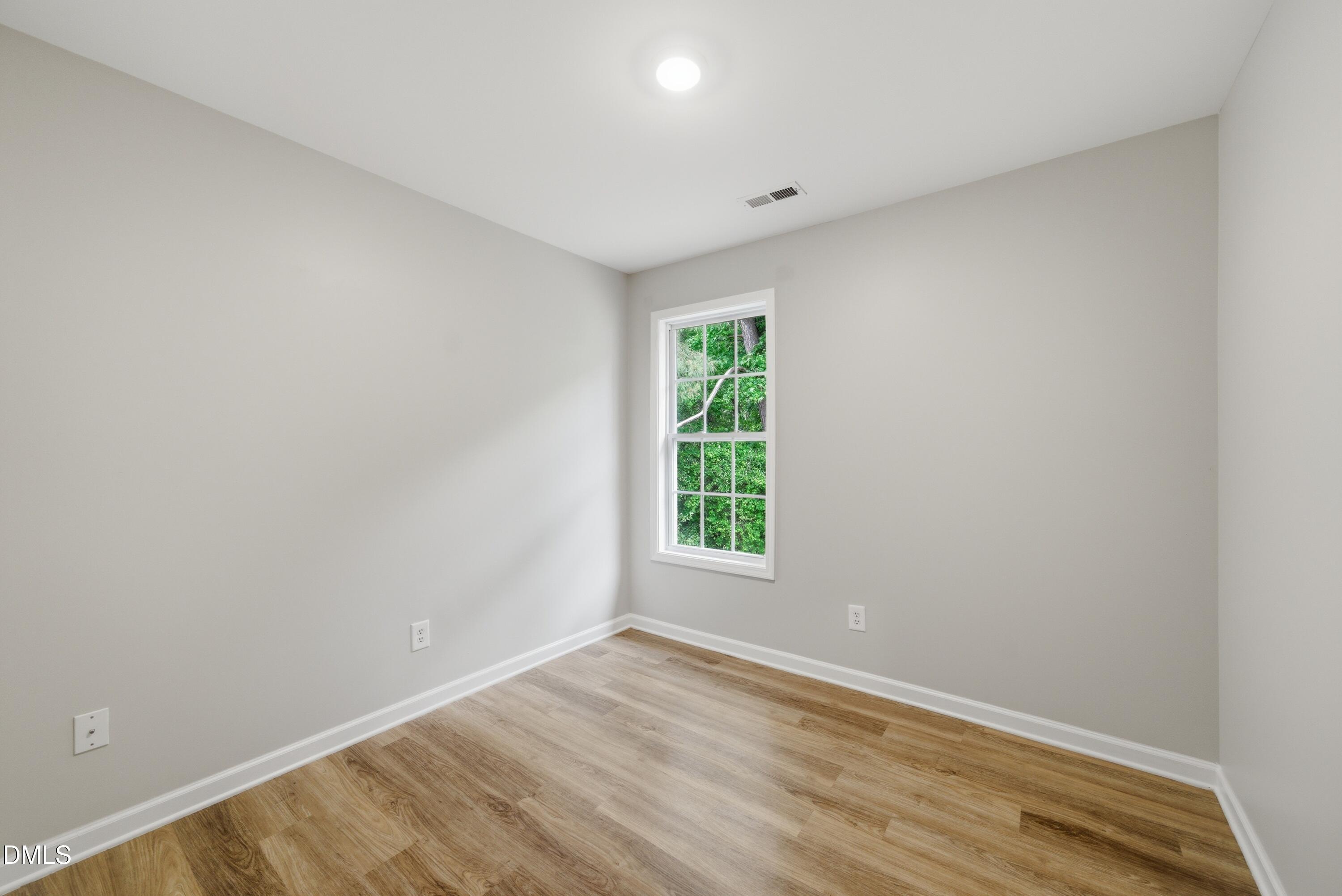 201 Tonylee Court, Unit A Raleigh, NC 27603 - Photo 27 of 30 a view of an empty room with wooden floor and a window