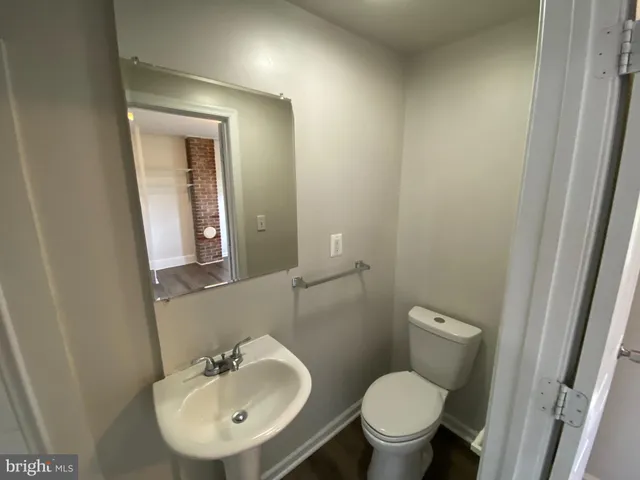 a bathroom with a toilet sink and mirror