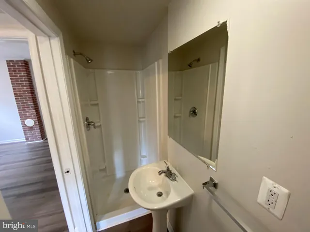 a bathroom with a sink a toilet a mirror and shower